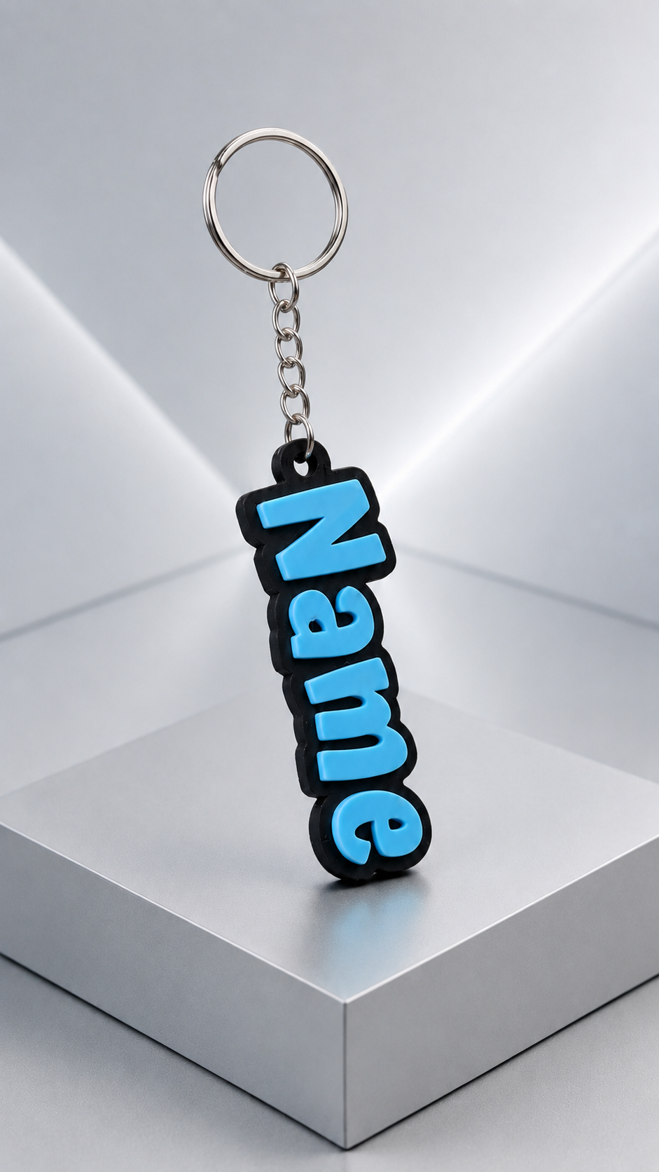 Custom 3D-printed name keychain with blue raised letters on a black backing