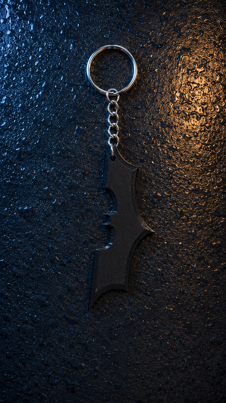 Top view of Batman 3D printed keychain in blue and gold lighting